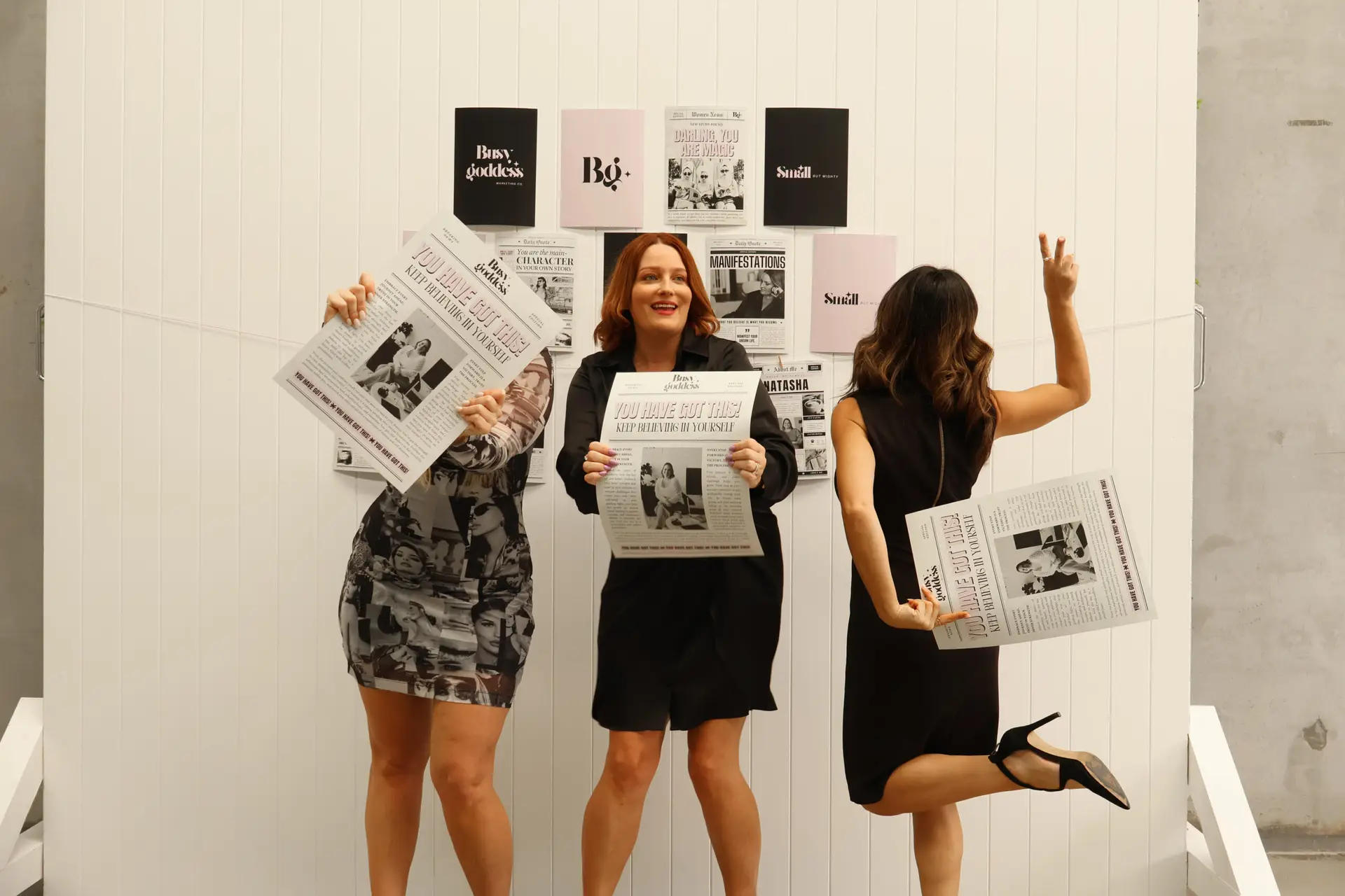 Natasha Panetta founder in front of Get Shit Done sign seated in chair smiling happily